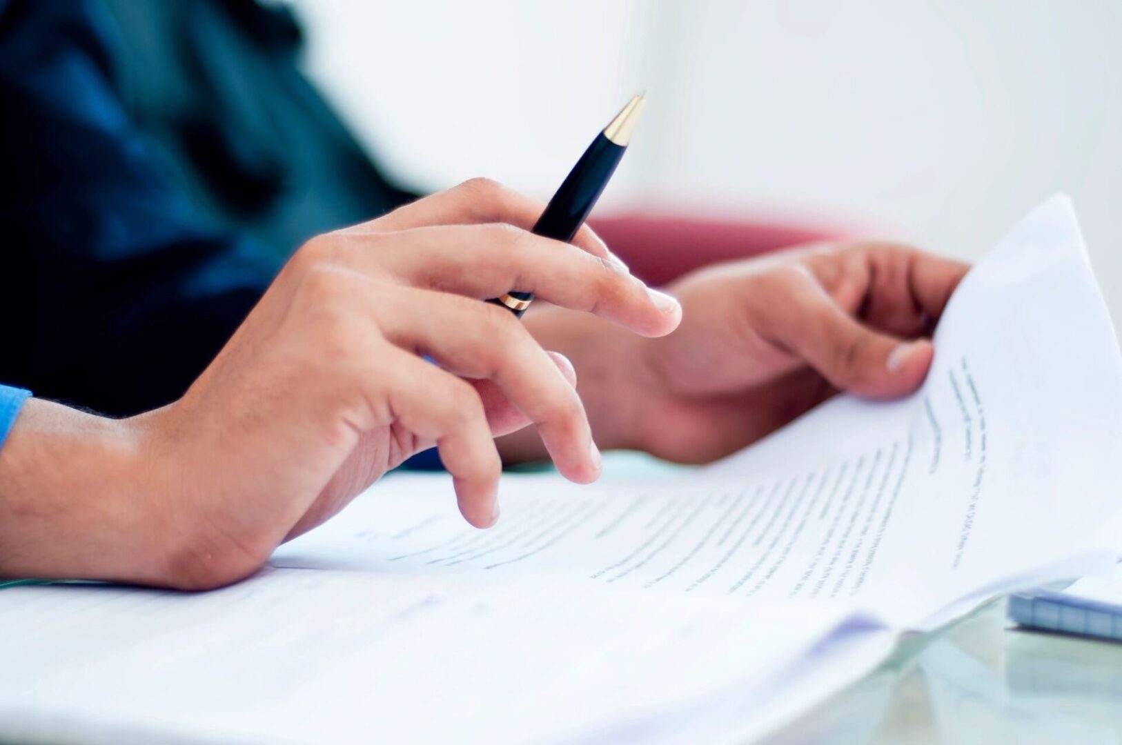 Person reviewing document with pen.