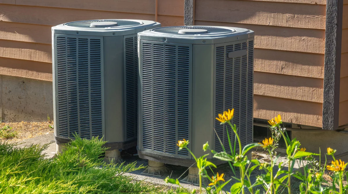 Two air conditioner units outside a house.