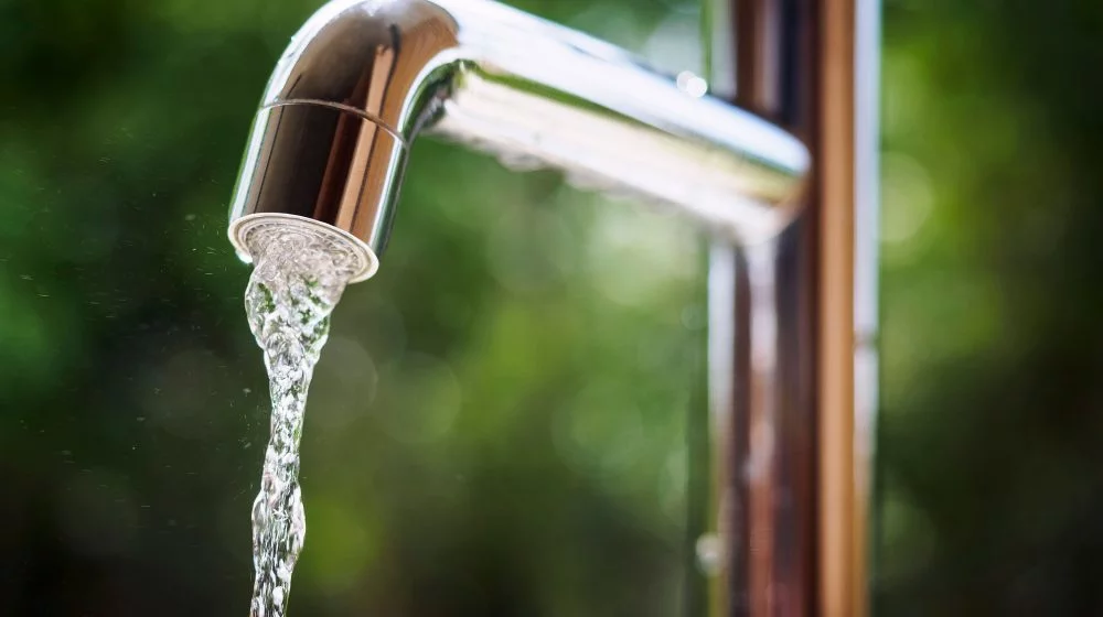 Water flowing from a chrome faucet.